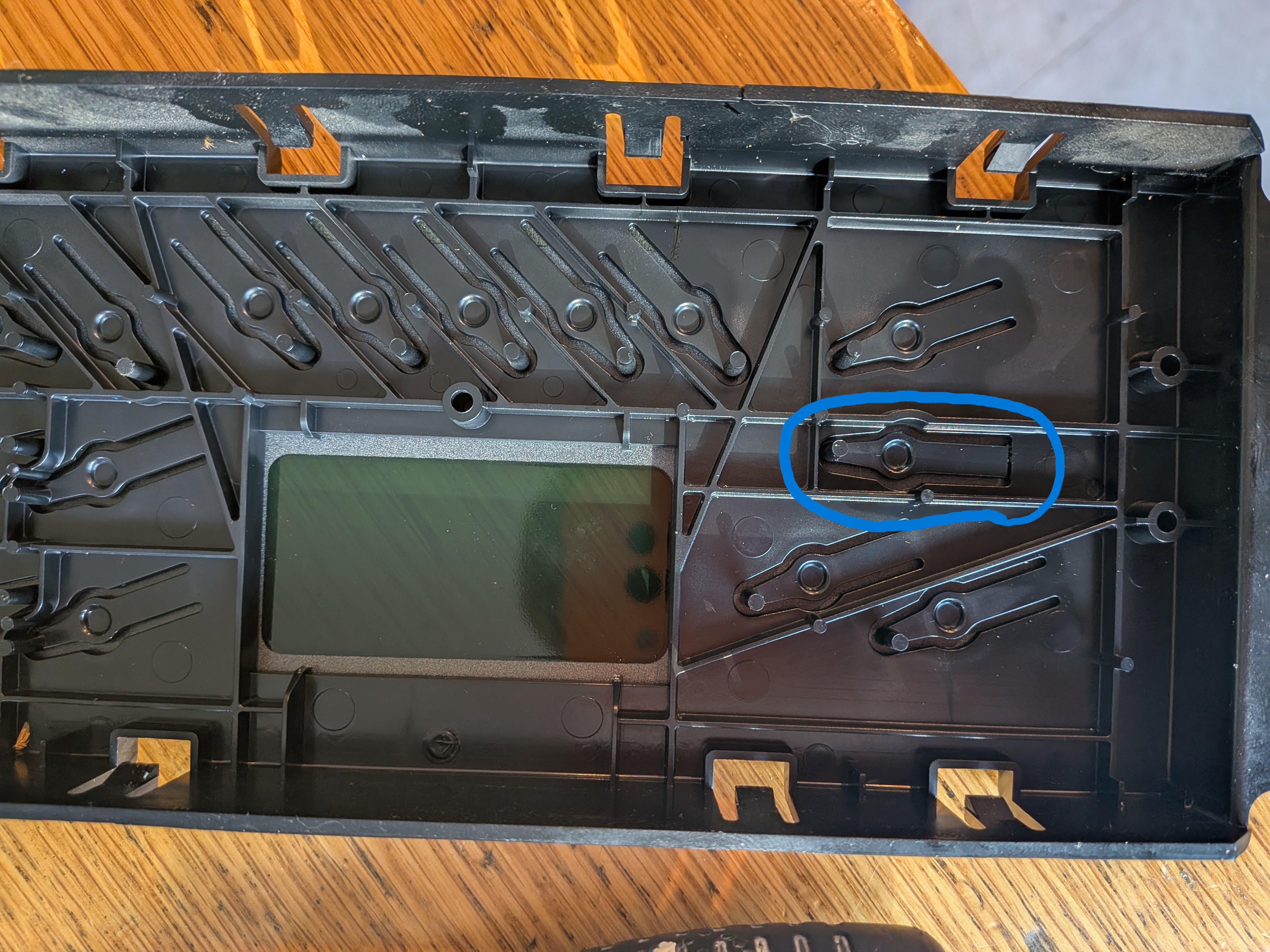Back side of the control panel, broken plastic finger is circled.