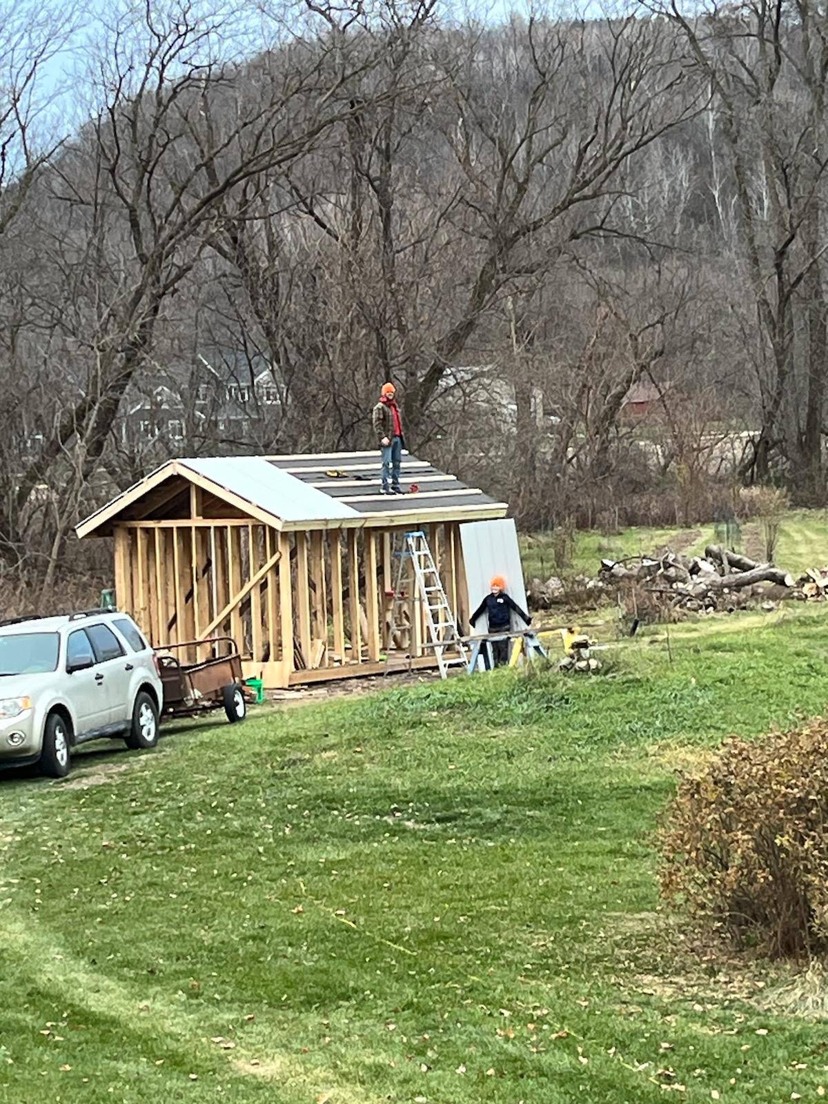 A picture of the sauna/office about a week before I fell off the roof and broke my wrist. The steel roof is half-installed and my son is helping me.