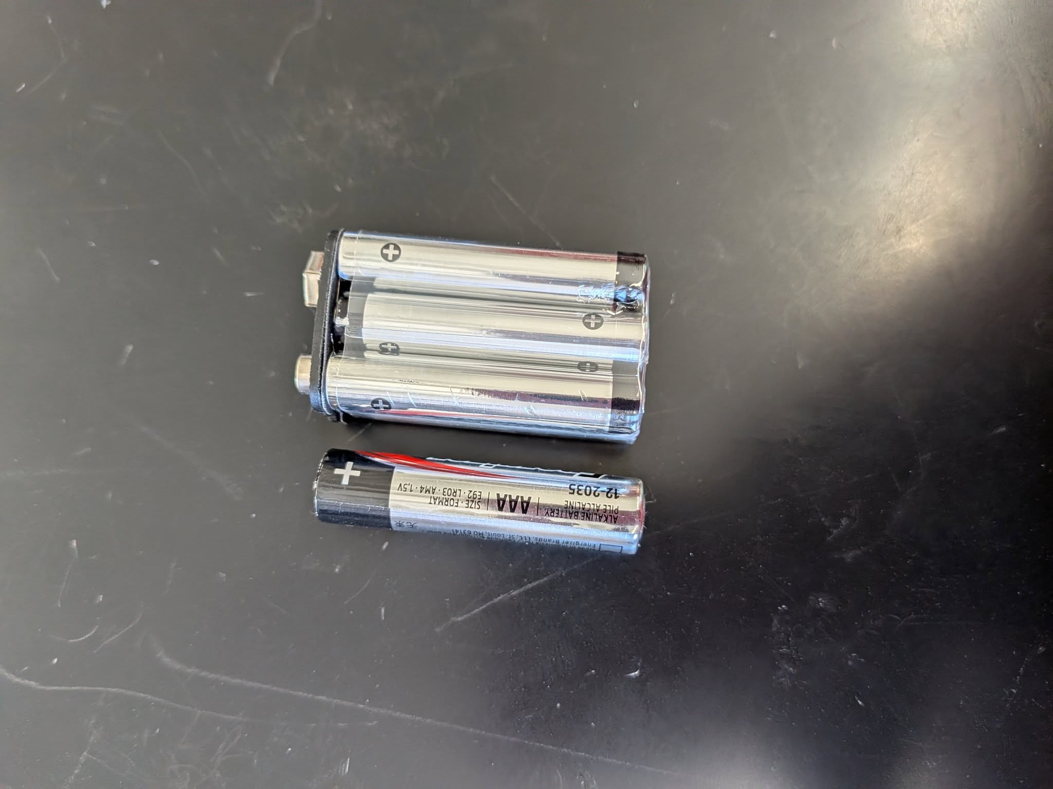 A 9v battery is made of AAAA batteries, which are slightly smaller than AAA size